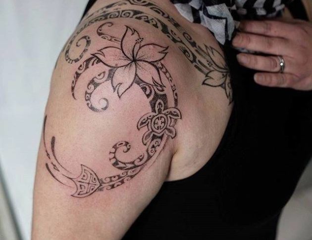 Полинезийская тату с цветком на плече девушки